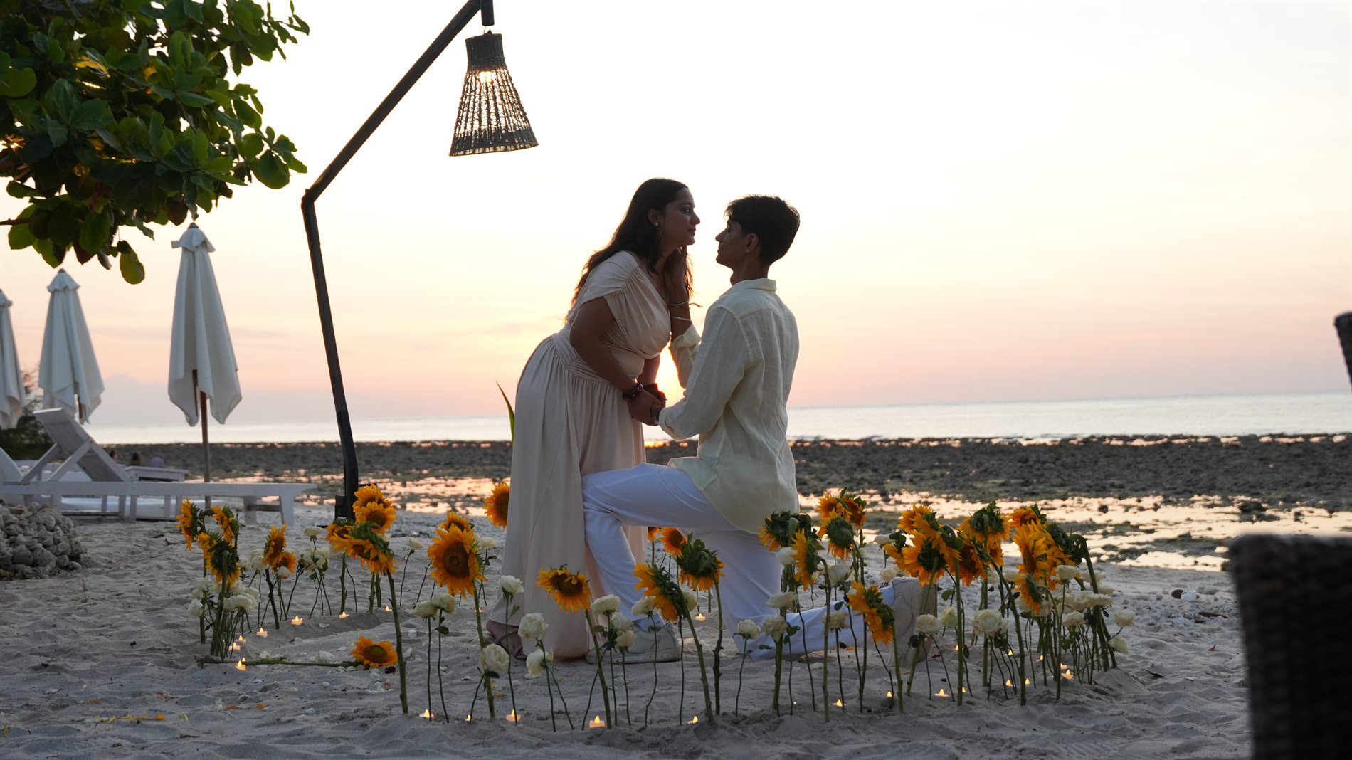 Beach proposal with sunflower setup at sunset